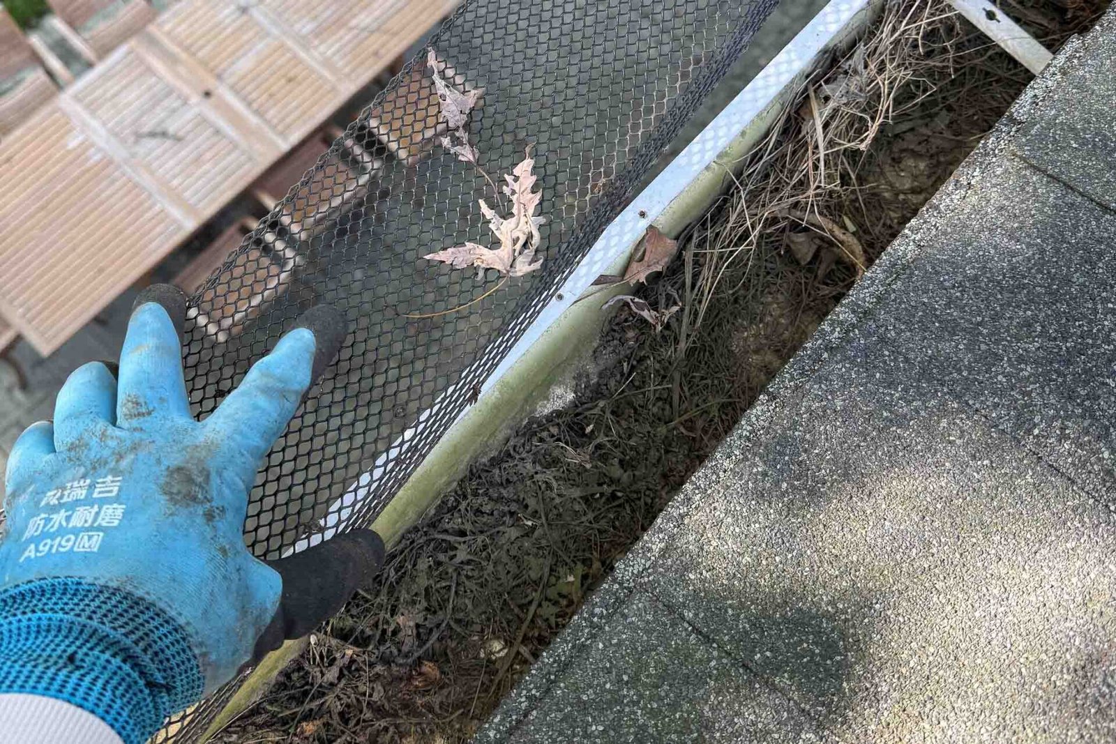 Clean gutter after debris removal, with the gutter guard being reinstalled on a Naperville home.